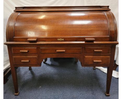 TEAK ROLL TOP CYLINDER DESK circa 1930s, the revolving cylindrical top opening to reveal a fitted interior and pull out desk 