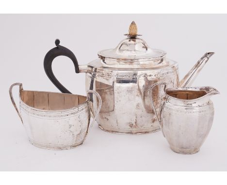 A three piece silver tea service by the Goldsmiths &amp; Silversmiths Company comprising of a teapot with decorative 'pineapp