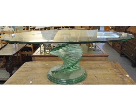 Unusual oval glass coffee table, the base with twisted step design. (B.P. 21% + VAT)&nbsp; &nbsp; &nbsp; &nbsp; &nbsp;The tab