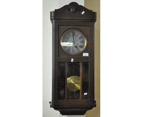 Mid century oak two train wall clock with brass pendulum and key.  (B.P. 21% + VAT) 
