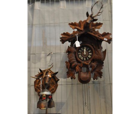 Carved, probably walnut Cuckoo Clock with stags head, animals and rifles on chain with cone waits, together with an Austrian 