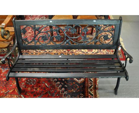 Painted and wooden cast iron two seater garden bench, the back decorated with pierced roses and foliage.  (B.P. 21% + VAT) 