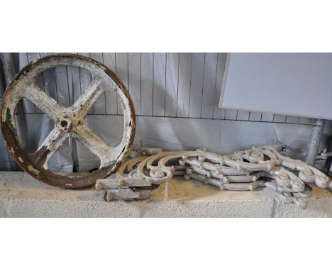 Two pairs of cast iron scroll decorated table/bench ends, together with a cast iron painted wheel.   (B.P. 21% + VAT) 