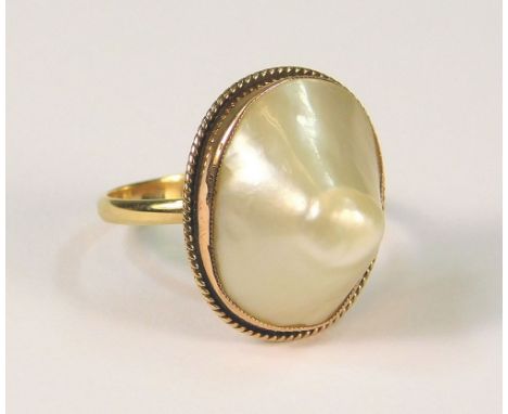 MABE PEARL. A Mabe pearl ring in 9ct. gold rub-over, rope twist setting, (K/L).