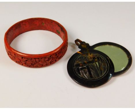 BANGLE ETC. A cinnabar lacquered bangle &amp; an Art Deco, faux tortoiseshell mirror/pendant.