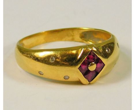 GOLD RING. An 18ct. gold ring, the front set an arrangement of calibre cut rubies, each shoulder set with three diamonds, (N)