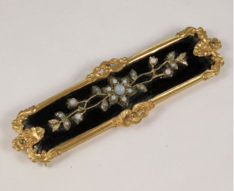 HINGED BUCKLE. A 19thc long gilt metal, hinged buckle for clothing. Set throughout with moonstones on a black enamel ground &