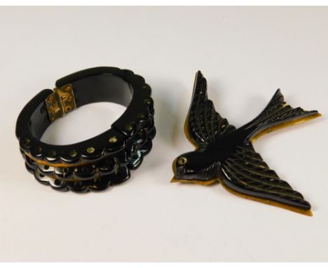 DECO BROOCH ETC. An Art Deco brass &amp; black celluloid flying bird brooch, width 8.5cm &amp; a similar hinged bangle.