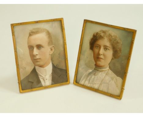 PORTRAIT MINIATURES. A pair of Edwardian hand tinted photographic portraits. Matching gilt metal frames, each with strut &amp