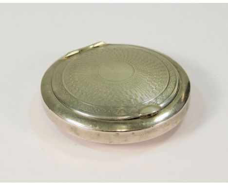 COMPACT. A silver compact with engine turned mirrored lid, diameter 5cm.