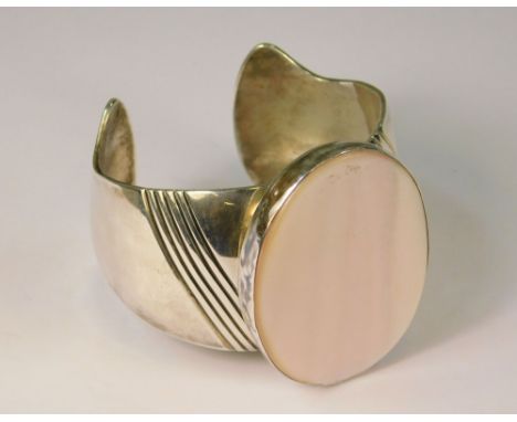 SILVER BANGLE. A large hand made silver cuff bangle, the front set with mother of pearl.