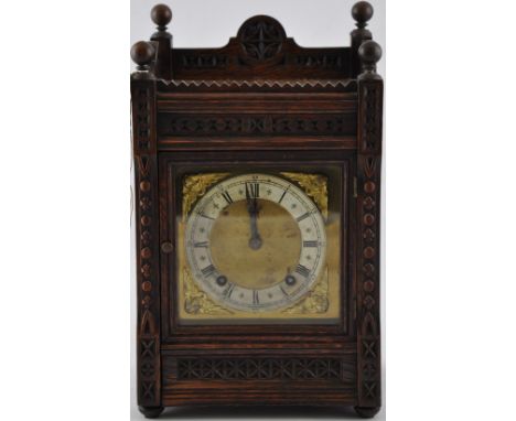 An oak cased mantel clock, with chip-carved decorated and silvered chapter ring set out in Roman numerals, the movement strik