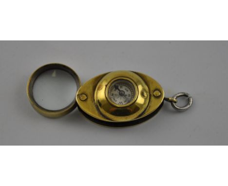 An early 20th Century oval brass loupe combined dry card compass, fob mount, L. 4cm.