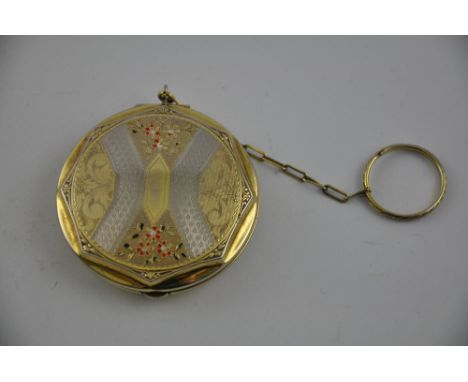 A 1950s circular enamelled gilt metal compact with engine turned and floral decoration, chain hung.