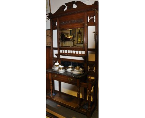 A late Victorian carved oak hallstand with rectangular bevelled mirror over marble surface, a drawer on ring turned underfram
