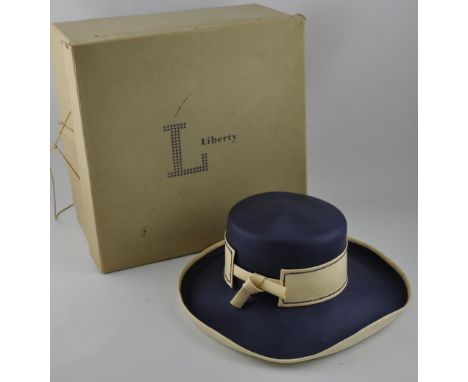 An Atelier Lucas ladies hat, of dark blue and cream straw, within a Liberty's hat box.