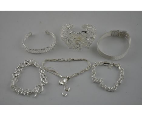 A white metal filigree bangle, stamped S925, together with other two white bangles and three further bracelets, 118g.