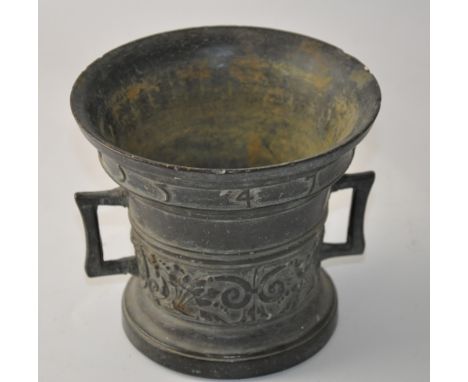 A 16th century style bronze mortar, of typical form cast with a band of foliage and dated to the rim, H. 14cm.