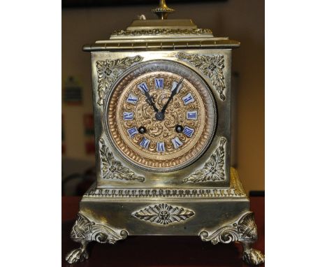 A late 19th century French gilt brass mantel clock, the embossed gilt dial with applied ceramic tablet Roman numerals, H. 24c