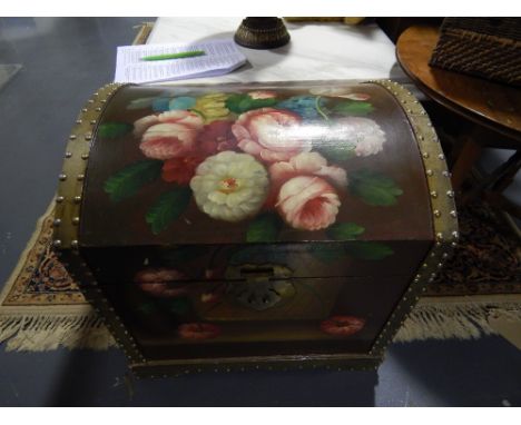 A painted wood dome top trunk decorated with a vase of roses.