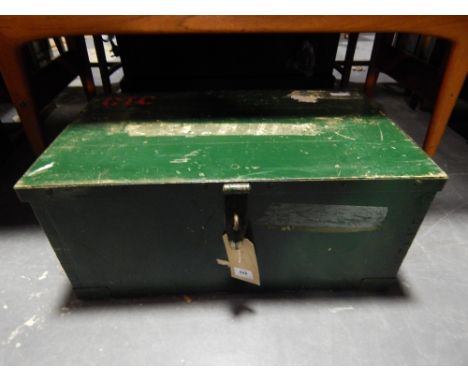 A green painnted rectangular pine trunk bears military markings.