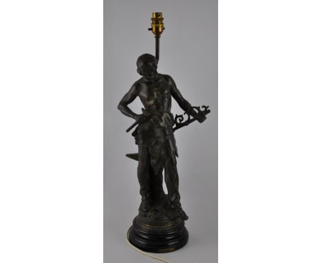 An early 20th century spelter lamp, cast in the form of a figure emblematic of industry, H. 61cm.