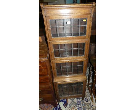 A 1930s oak four-tier lead glazed narrow bookshelf by Minty, labelled to interior, w.47cmCondition report: Good condition. Tw