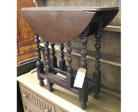 An antique joined walnut drop flap occasional table, raised on bobbin turned supports with gateleg action, width 75.5cm