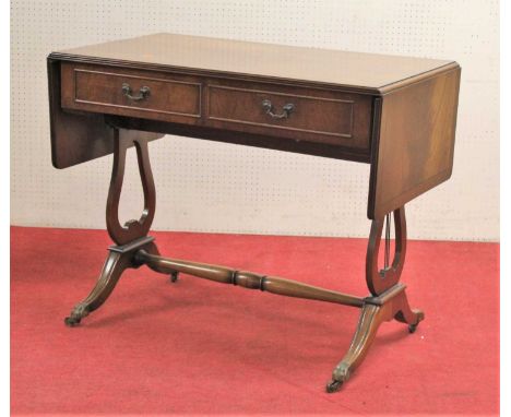 A contemporary mahogany and crossbanded sofa table in the Regency taste, having twin frieze drawers, raised on lyre end suppo