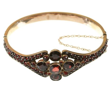 A VICTORIAN ALMANDINE GARNET HINGED BANGLE, IN GILT BRASS++LIGHT WEAR AND SCRATCHES CONSISTENT WITH AGE