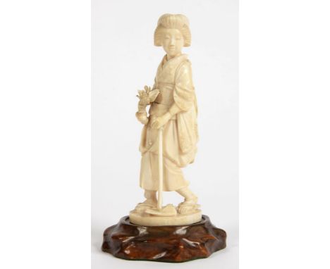 A JAPANESE IVORY FIGURE OF A WOMAN WITH MATTOCK AND VEGETABLES, 14.5CM H, EARLY 20TH C, WOOD STAND