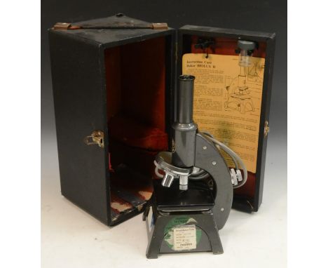 A Baker Biolux monocular microscope, three objectives, 31.5cm high, cased, instruction card ensuite