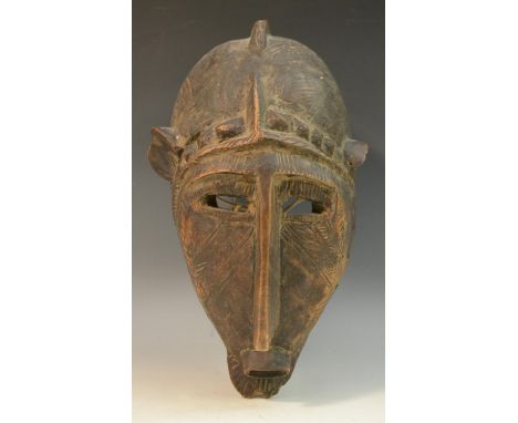 Tribal Art - a Bambara Ntomo society mask, domed 'half-helmet' with central ridge, pronounced nose and scarified features, 35