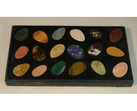 A pietra dura rectangular desk weight, inlaid with pebble shaped reserves of malachite, amethyst quartz, lapis lazuli and oth