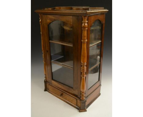 A Victorian walnut table top display cabinet, serpentine caddy top above an arched glazed door flanked by turned quarter-colu