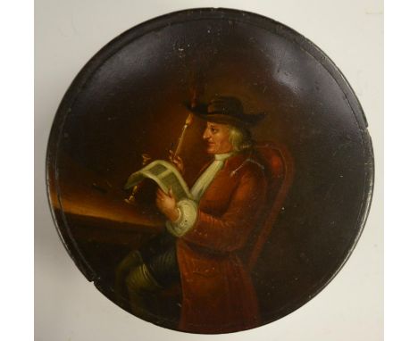 A 19th century papier-mâché circular table-top snuff box, the cover humorously painted with a gentleman reading by candleligh