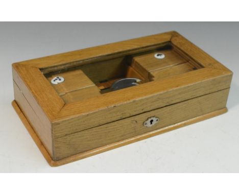An Edwardian oak playing card box, hinged cover with bevelled glass panel enclosing counter boxes applied with each of the fo