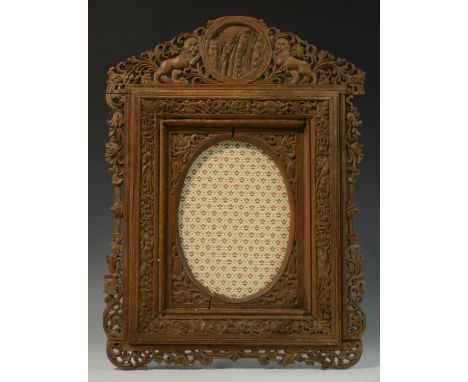 A 19th century Indian sandalwood shaped rectangular easel photograph or picture frame, pierced and profusely carved with dens