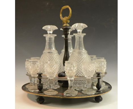 An early 19th century three bottle tole work decanter stand, painted in red, green and yellow with panels and leafy scrolls, 