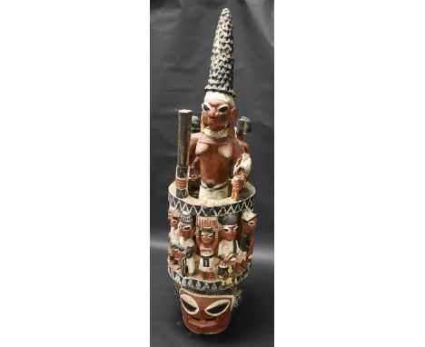 Tribal Art - a large Yoruba Epa mask, carved as a female figure holding a club and a rooster, above a band of figures upon a 