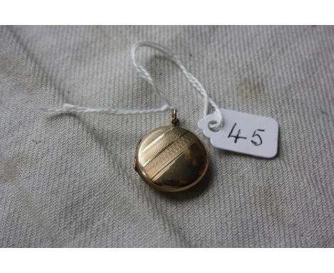 A circular back &amp; front locke with engine turned decoration in 9ct - 3.5gms