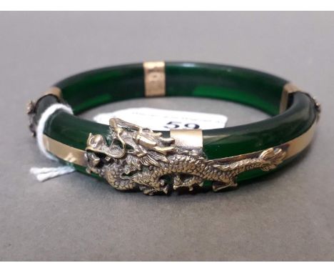 An imitation jade bangle with metal dragon mounts. 