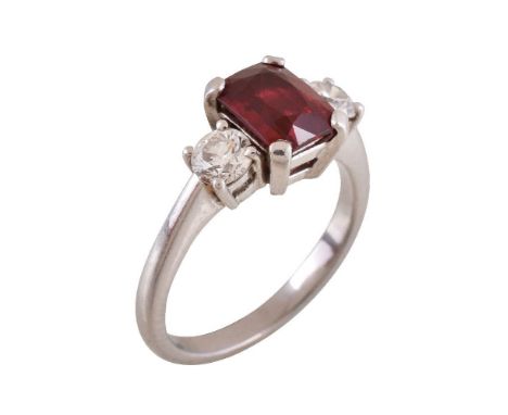 A ruby and diamond three stone ring, the step cut  ruby flanked by brilliant cut diamonds, approximately 0.60 carats total, f