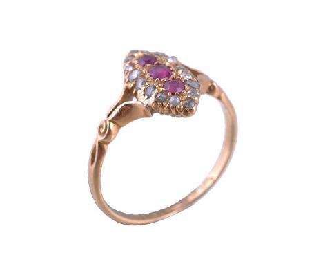 An Edwardian ruby and diamond ring, the marquise shaped panel set with three graduated oval cut rubies, within a surround of 