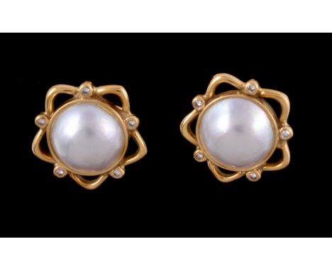A pair of mabé pearl and diamond earrings, the circular mabé pearls within a pierced star shaped setting, with brilliant cut 