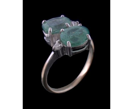An 18 carat green tourmaline and diamond ring, the two green tourmalines in a crossover design with two brilliant cut diamond