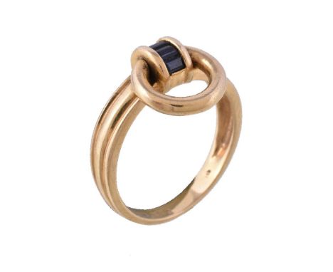 A sapphire ring, the reeded band set with rectangular cut sapphires, with a polished loop, stamped 750, finger size O, 4.4g