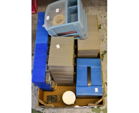 Various plastic table top drawer banks containing an extensive collection of clock repair related parts and tools etc. 