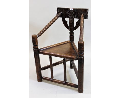 Oak Turner's chair in 17th Century style, the chip carved back and bobbin turned arms above a triangular seat on turned suppo