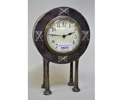 Pewter circular cased mantel clock of stylised form, with circular enamel dial having Arabic numerals on four hexagonal suppo